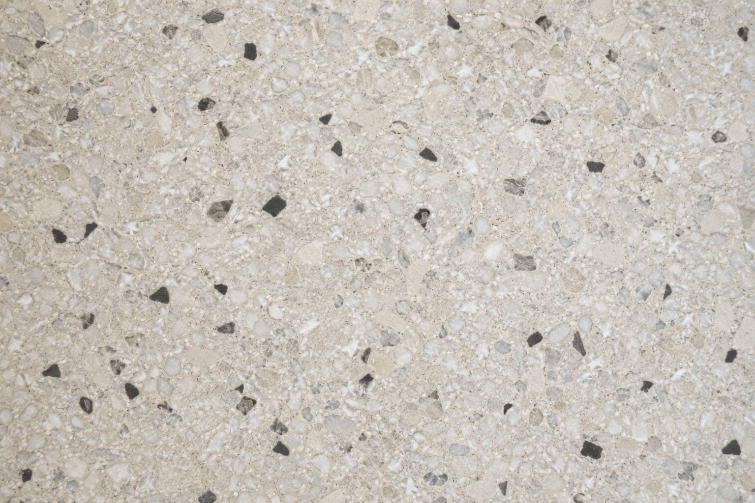 Lastryko stracciatella — jasne mleczne tło z pojedynczymi czarnymi okruchami, terrazzo po szlifie